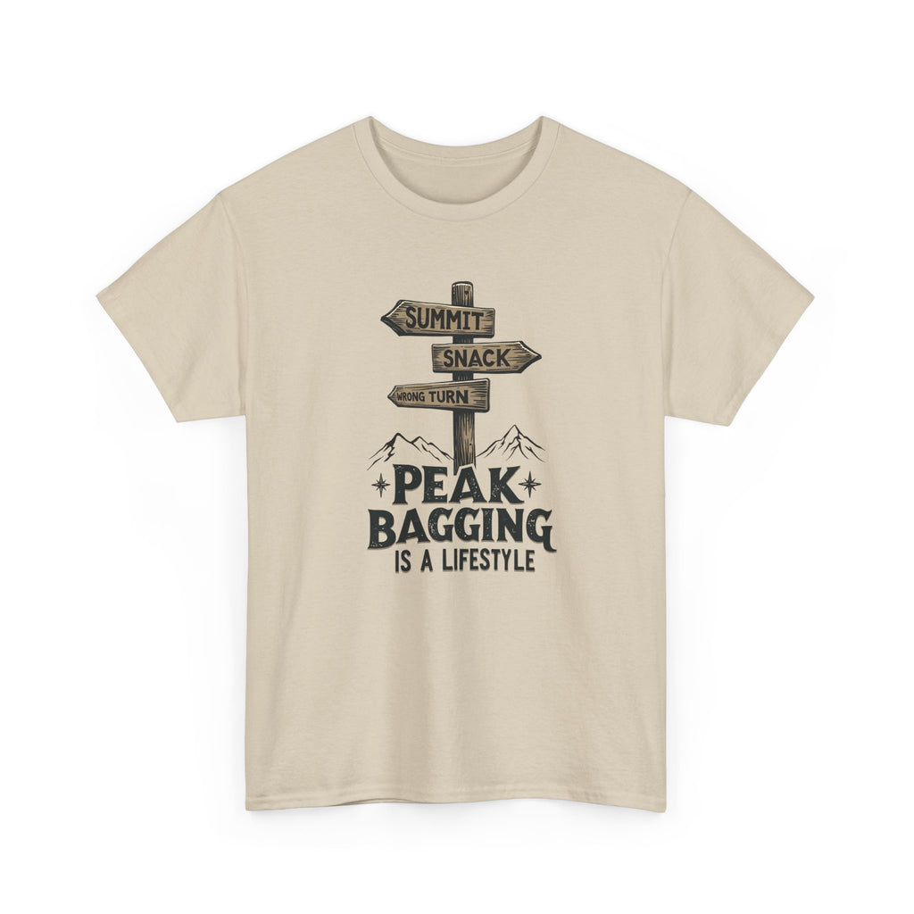 Beige t-shirt with mountain-themed graphic and text 'peak bagging is a lifestyle' on a white background