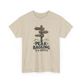 Beige t-shirt with mountain-themed graphic and text 'peak bagging is a lifestyle' on a white background