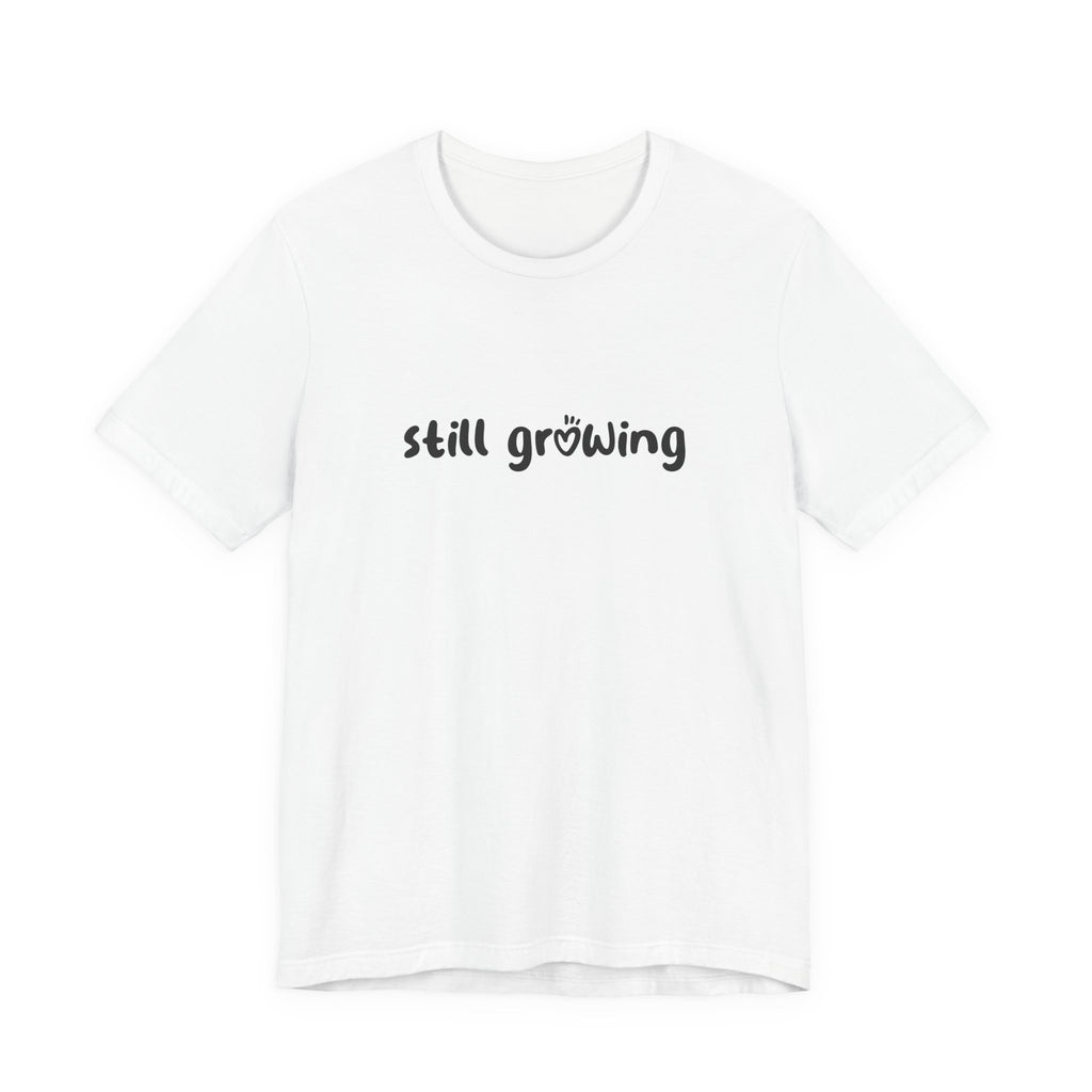 White t-shirt with 'still growing' text on a white background